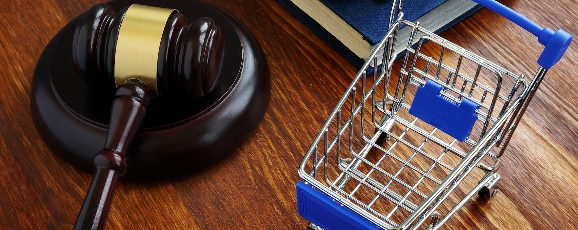 Consumer protection law concept. Shopping cart and gavel.