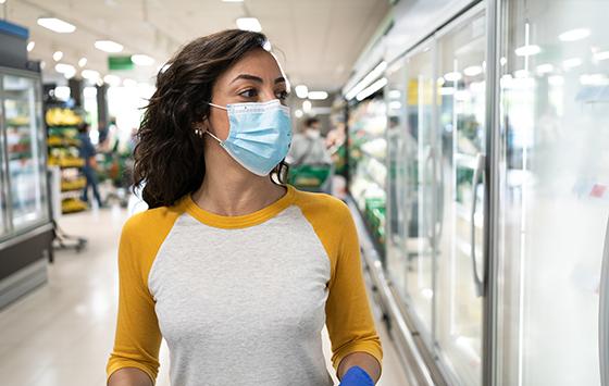 Woman wearing a mask to prevent infection inside a supermarket i